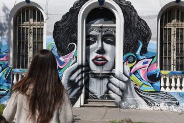 A woman walks past street art in Bellavista neighbourhood.