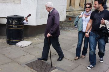 A street busker hides in a litter bin A street busker hides in a litter bin to illustrate Professor to sue Cambridge over ‘forced retirement’ rules