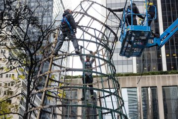Workers disassemble a tree structure in New York Workers disassemble a Tree in New York to illustrate Main graduate school admissions test revised as use drops by half