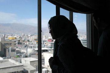 Woman looking out of a window in Tehran, Iran Woman looking out of a window in Tehran, Iran to illustrate ‘Blind growth’ of Iran’s universities ‘worsened’ high unemployment