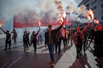 Students hold flares as they take part in a demonstration against the government's plans for private universities to illustrate Private universities law will stem Greek diaspora, minister says