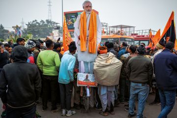 Devotees gather near an effigy of Indian prime minister Narendra Modi at the Ram Mandir Temple to illustrate Political attacks on Indian HEIs must end