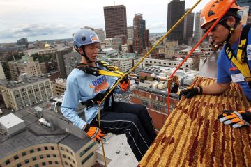 Person abseil on side of building with person watching to illustrate Trust-based bookkeeping could prompt timid partnering