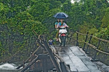 Two people ride on a motorbike across the wooden bridge in the Karen State, Myanmar. Two people ride on a motorbike across the wooden bridge in the Karen State, Myanmar to illustrate No education ‘better than oppressive one’ for Myanmar students