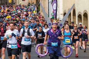 Huge crowd of runners with a charity runner wearing a scissors fancy dress costume Huge crowd of runners with a charity runner wearing a scissors fancy dress costume to illustrate ‘£3 billion cut’: inflation analysis reveals loss
