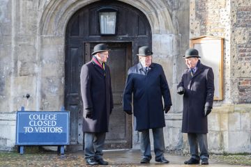 Trinity college at the University of Cambridge, England. Men standing at closed door with sign reading 'College to to visitors' to illustrate Elitism cannot be fixed without Oxbridge admissions reform