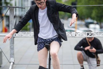 Street performer removes his trousers while riding a unicycle Christchurch, New Zealand to illustrate New Zealand universities ‘losing money’ on crucial subjects
