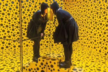 An immersive installation with a person looking into a mirror box in a bright yellow room overrun with black dots in Adelaide Australia to illustrate Purge of lectures at Adelaide ‘breaches co-creation commitment’
