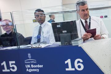 Border Force check the passports of passengers arriving at Gatwick Airport to illustrate Immigration check refusenik stripped of Keele fellowship
