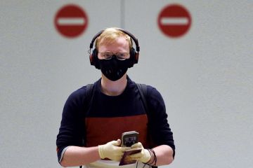 A passenger wearing PPE with two no entry signs behind him. A passenger wearing PPE with two no entry signs behind him.