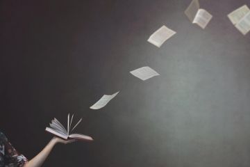 Concept image of pages flying from a book held by a woman Concept of pages flying from a book held by a woman to illustrate REF rules on open access books will have major consequences