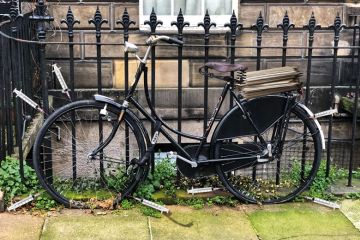 Old style bicycle with flat tyres chained up on fence railings with syringes around the wheels Old style bicycle with flat tyres chained up on fence railings with syringes around the wheels to illustrate Social research is being stymied by excessive ethical oversight