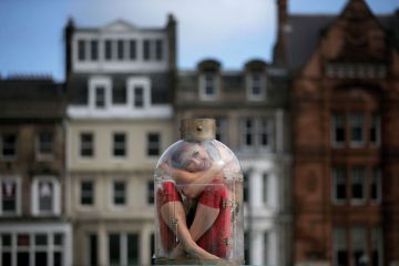 Contortionist Odka, from Cirque Berserk, sitting in a tiny bottle Contortionist Odka, from Cirque Berserk, sitting in a tiny bottle to illustrate ‘Pod-sized’ rooms plan to reduce UK student rents