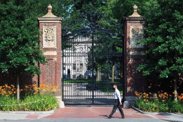 Harvard University person walking infront of closed entrance. Harvard University person walking infant of closed entrance as a metaphor for rejection
