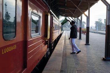 Train conductor giving wave with a green flag at Colombo fort train station. Train conductor giving wave with a green flag at Colombo fort train station to illustrate Professor departs South Asian University after Modi criticism row