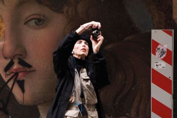 Tourists pass-by a renaissance painting to illustrate Renaissance of ‘Italian Erasmus’ gets mixed reception