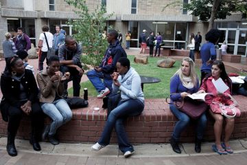 Students chat outside lecture halls at the University of the Free State in Bloemfontein, South Africa. Races are mixing more but often they socialize with their own kind. Students chat outside lecture halls at the University of the Free State in Bloemfontein, South Africa. Races are mixing more but often they socialize with their own kind.