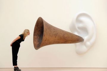 Woman leans in looking at an installation installation by US artist John Baldessari entitled ‘Beethoven’s Trumpet (With Ear)’ as a metaphor for universities will ‘listen to students’