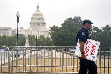 A U.S. Capitol police officer carries "Area Closed" signs in front of the U.S. Capitol A U.S. Capitol police officer carries "Area Closed" signs in front of the U.S. Capitol to illustrate Could US education department be shut?