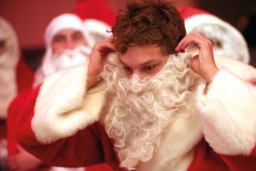 A participant puts on his Santa beard during a gathering of volunteer student Santas and angels in Berlin, Germany A participant puts on his Santa beard during a gathering of volunteer student Santas and angels in Berlin, Germany