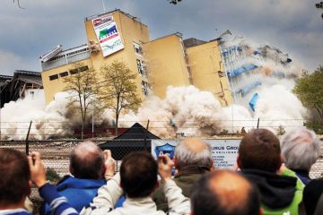 Residents watch a controlled demolition in the Netherlands Residents watch a controlled demolition in the Netherlands to illustrate Overseas student caps in limbo after Dutch government collapses