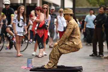 Tourists watch a mime artist perform in Sydney Tourists watch a mime artist perform in Sydney to illustrate Australian vice-chancellors’ pay rises ‘paused’ post-pandemic