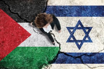 Woman walking over cracked paving made up of Palestine and Israel flags Woman walking over cracked paving made up of Palestine and Israel flags