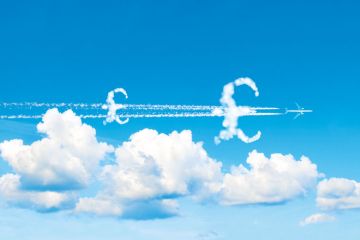 Montage of plane flying with £ symbol clouds Montage of plane flying with £ symbol clouds to illustrate We need cash incentives to shrink carbon footprints
