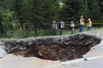 Hikers looking at a sinkhole that measures 25x20 feet and approximately 50-60 feet deep in Colorado to illustrate Review finds billion-dollar hole in Johns Hopkins medicine budget