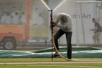 A man tries to place a water sprinkler on a field in Singapore A man tries to place a water sprinkler on a field in Singapore