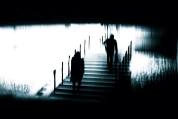 Silhouettes of unrecognizable people in motion blur walking on an urban staircase to illustrate Academic life with sight loss