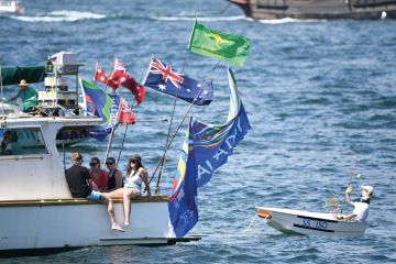 A small boat is being towed on the harbour in Sydney, Australia by a  large boat with people relaxing on board to illustrate the pay disparity data reveal elite clique in Australian universities 