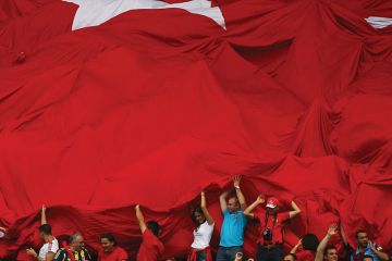Fans of Turkey roll out the Turkish flag in support of their team
