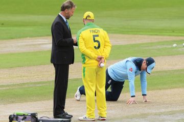 England captain Eoin Morgan inspects the pitch as match referee Chris Broad (l) chats with Australia captain Aaron Finch