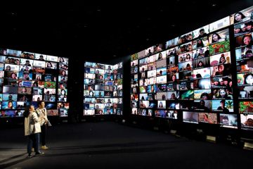 People on screens two people standing laughing. People on screens two people standing laughing.