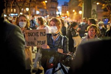 A member of the crowd watching the National Tribute to the murdered school teacher Samuel Paty holds a placard reading 'Do not touch my Professor' at Place de la Sorbonne on October 21, 2020 in Paris, France A member of the crowd watching the National Tribute to the murdered school teacher Samuel Paty holds a placard reading 'Do not touch my Professor' at Place de la Sorbonne on October 21, 2020 in Paris, France.