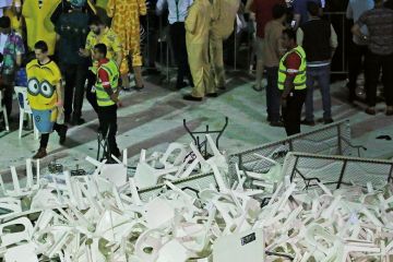 Security guards stand around a pile of plastic chairs and tables to illustrate Australian research review urges action on time wasting, interference
