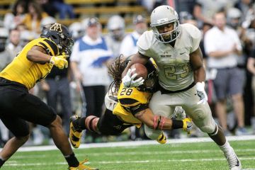Running back Aaron Duckworth of the Idaho Vandals carries a tackler with him during first half action against the Appalachian State Mountaineers to illustrate Pushback mounts as Idaho nears Phoenix purchase