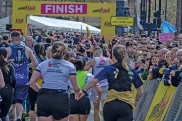 Runners holding hands approach the finish line at the London Landmarks Half Marathon 2024 Runners holding hands approach the finish line at the London Landmarks Half Marathon 2024 to illustrate record numbers are getting clearing for university admissions