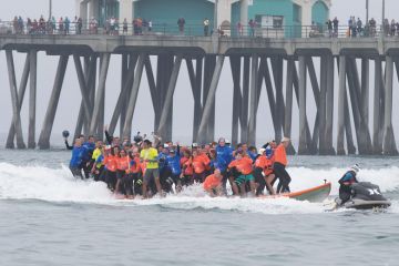 Crowds gather on the pier and the beach to watch surfing break the World Guinness Record for most people (66) on a surfboard and the biggest surf board (42 1/4 feet) in Huntington Beach, California Crowds gather on the pier and the beach to watch surfing break the World Guinness Record for most people (66) on a surfboard and the biggest surf board (42 1/4 feet) in Huntington Beach, California to illustrate Biden officials open to more three-year deg