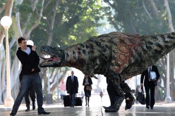 A Tyrannosaurus rex takes a morning stroll with commuters in Hyde Park n Sydney, Australia A Tyrannosaurus rex takes a morning stroll with commuters in Hyde Park n Sydney, Australia to illustrate Students protest against ‘predatory’ scholarship revocations