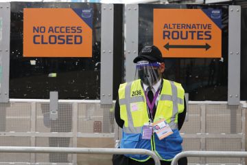 A steward in PPE including face mask and visor as a precaution against COVID-19 staffs a barrier at The London Stadium A steward in PPE including face mask and visor as a precaution against COVID-19 staffs a barrier at The London Stadium