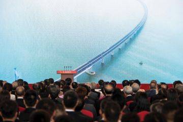 Guests watch a trailer on a giant screen during the opening ceremony of the Hong Kong-Zhuhai-Macau Bridge Guests watch a trailer on a giant screen during the opening ceremony of the Hong Kong-Zhuhai-Macau Bridge
