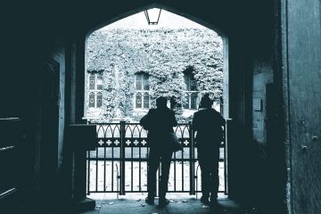 Two People looking over a gated entrance to illustrate Oxford professors ‘forced to retire’ win tribunal case