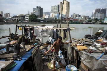 Worker collecting plastic bottles floating on the river at the banks of Pasig River in Manila to illustrate Philippines’ higher education ‘more unequal despite reforms’
