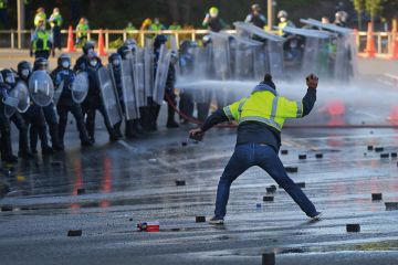 A man faces off with police near the parliament as police move in to clear protesters in Wellington A man faces off with police near the parliament as police move in to clear protesters in Wellington to illustrate We need support as threats worsen, says scholar who sued Auckland