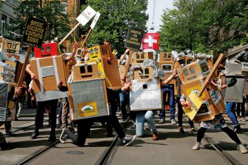 people dressed in boxes with banners as robots