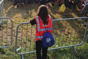 Security person holding gate at a festival Security person holding gate at a festival