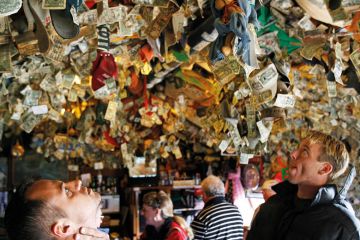 People looking up at pinned mementos left on the ceiling. People looking up at pinned mementos left on the ceiling.