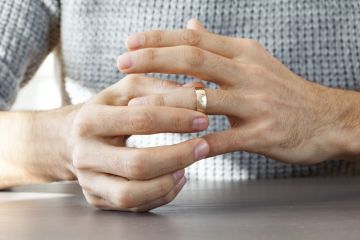 A man removes his wedding ring, symbolising exclusive partnerships